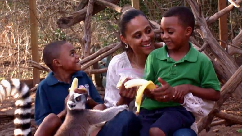 Marion Jones nourrit un lémurien avec ses enfants