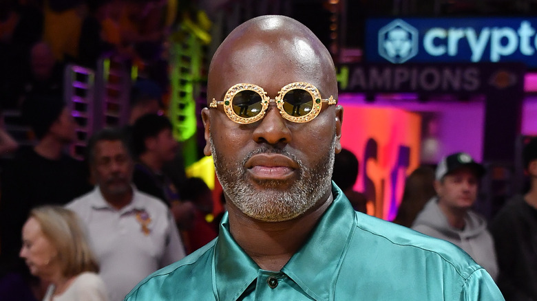 Corey Gamble posant dans des lunettes circulaires dorées