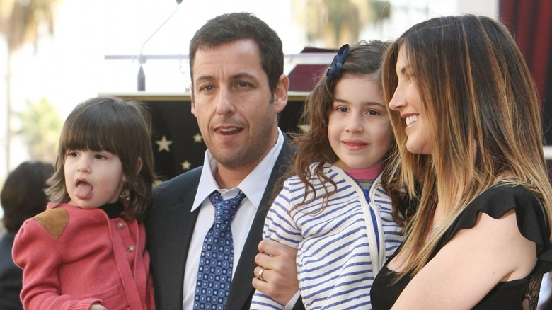 Jackie et Adam Sandler portant leurs filles