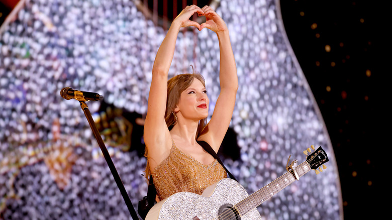 Taylor Swift fait un signe de cœur avec ses mains