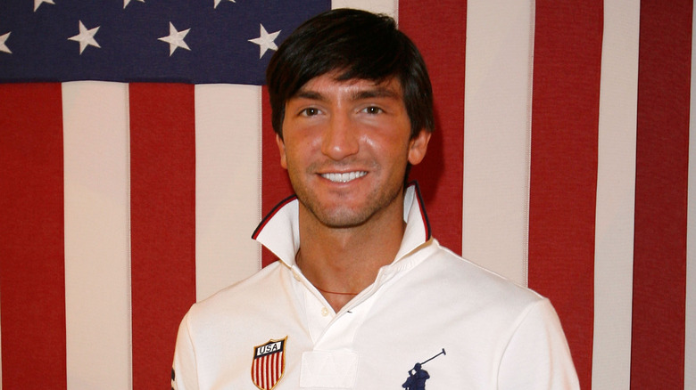 Evan Lysacek souriant devant le drapeau américain