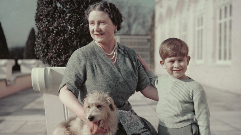 Le jeune prince Charles souriant avec la reine mère