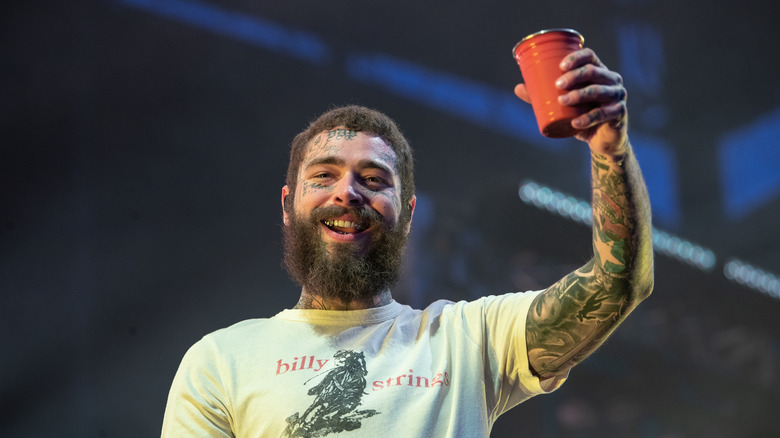 Post Malone tenant un verre