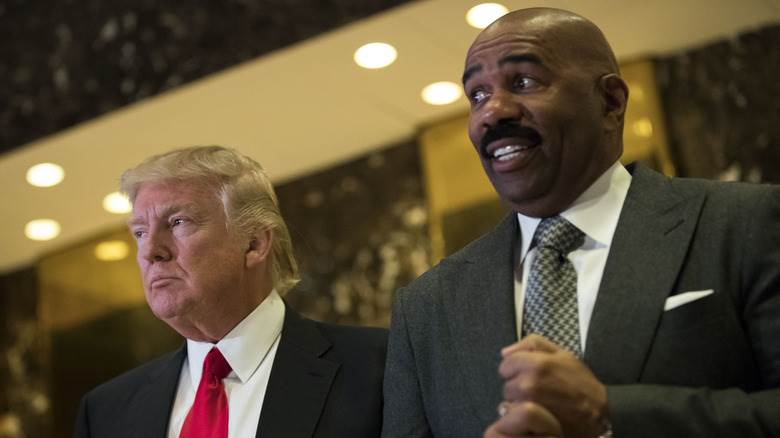 Donald Trump et Steve Harvey debout ensemble, Steve semblant mal à l'aise