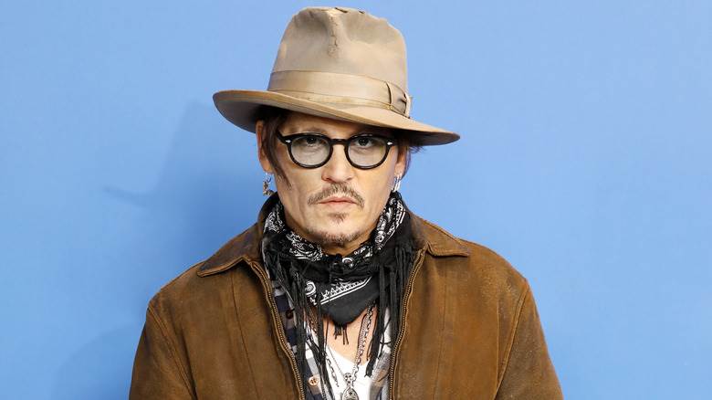 Johnny Depp pose avec un chapeau marron