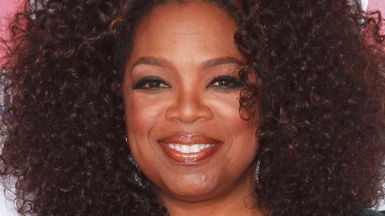 Oprah Winfrey souriante en haut vert