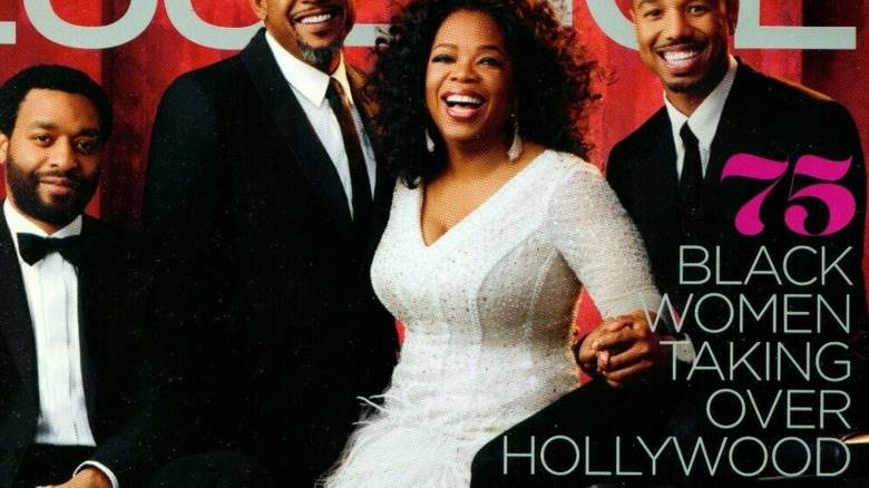 Oprah souriante dans une robe à plumes blanches