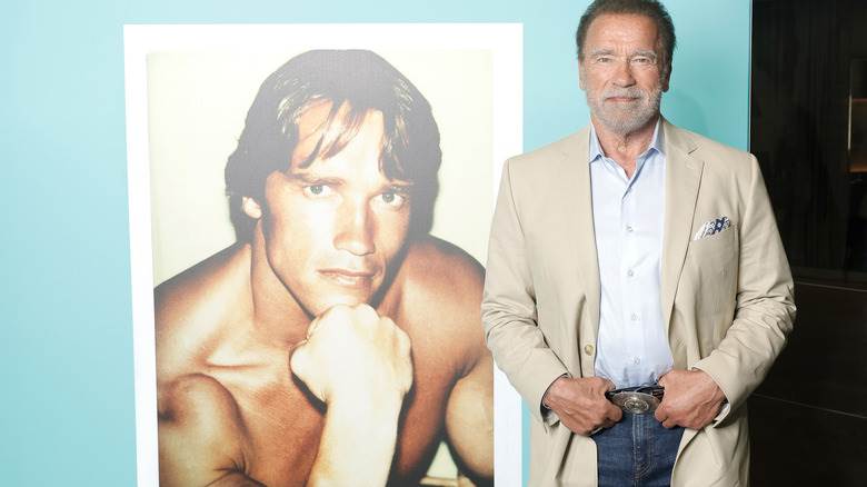 Arnold Schwarzenegger posant à côté d'une photo