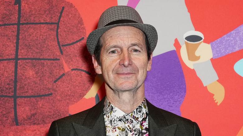 Denis O'Hare souriant bouche fermée sur le tapis rouge