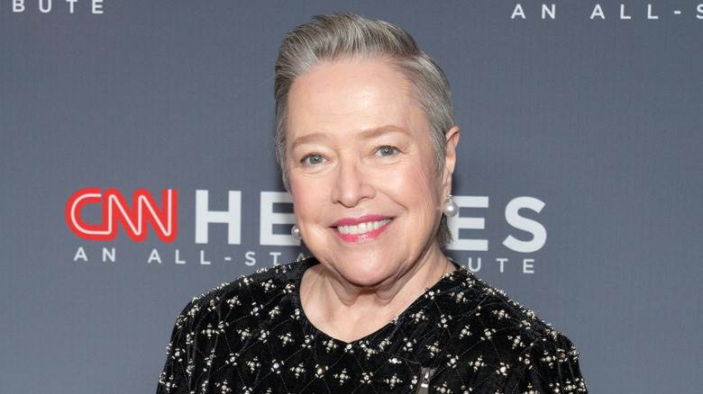 Kathy Bates souriant à la caméra sur le tapis rouge