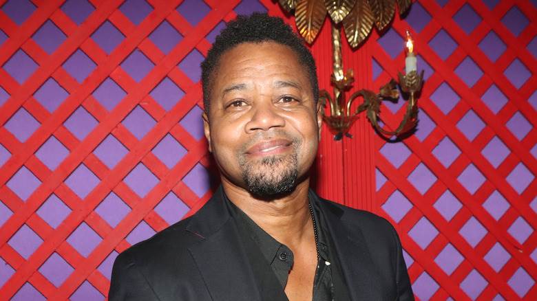 Cuba Gooding Jr. souriant bouche fermée avec le menton incliné