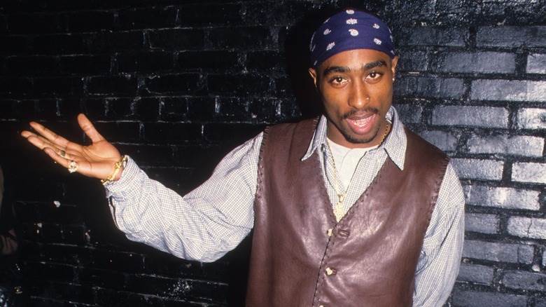 Tupac avec le bras étendu sur le côté