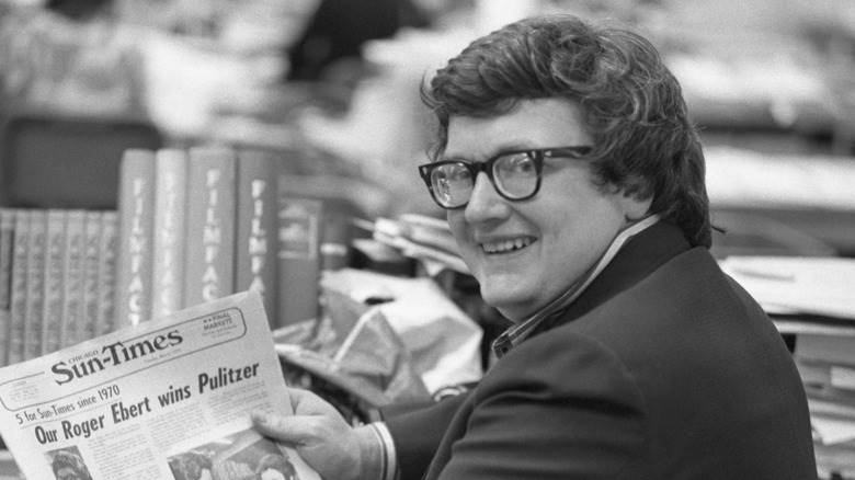 Roger Ebert pose avec un journal.