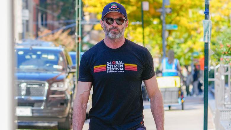 Hugh Jackman marche dans la rue avec un t-shirt, une casquette et des lunettes de soleil