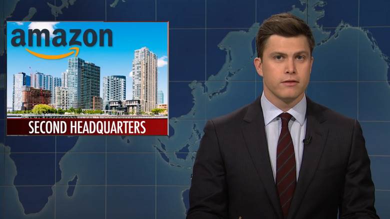 Colin Jost avec un graphique Amazon sur l'épaule