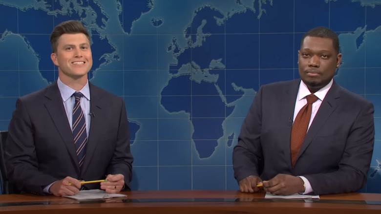 Colin Jost et Michael Che assis à leur bureau