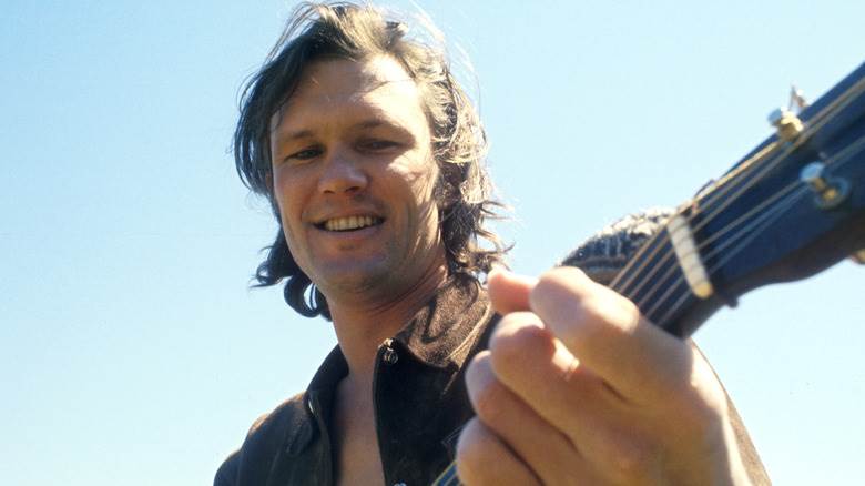 Kris Kristofferson pose avec une guitare