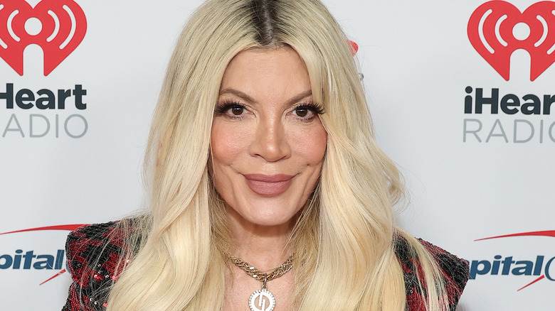 Tori Spelling souriante en rouge