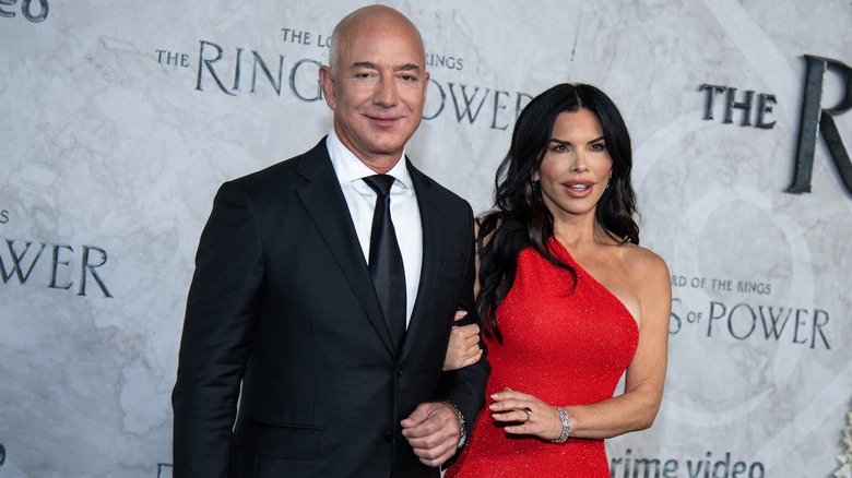 Jeff Bezos et Lauren Sanchez souriants lors d'un événement sur le tapis rouge