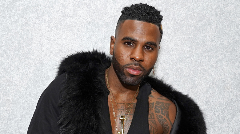 Jason Derulo posant contre un mur blanc