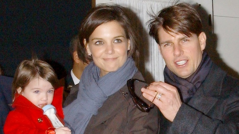 Katie Holmes portant Suri Cruise, Tom Cruise souriant