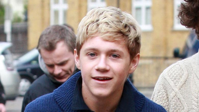 Le jeune Niall Horan souriant dans une rue