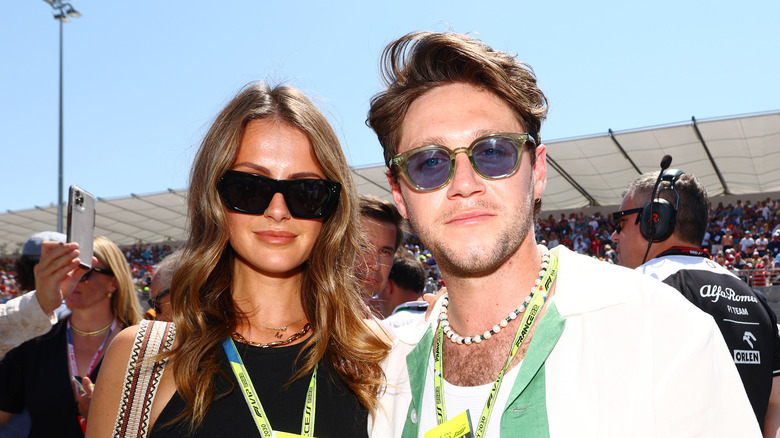 Niall Horan et Amelia Woolley se tiennent ensemble avec des lunettes de soleil