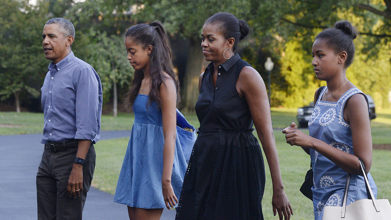 Sasha et Malia marchant avec Michelle et Barack Obama