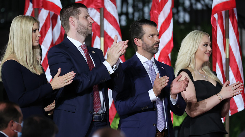 Ivanka Trump, Eric Trump, Donald Trump Jr. et Tiffany Trump se tiennent devant des drapeaux