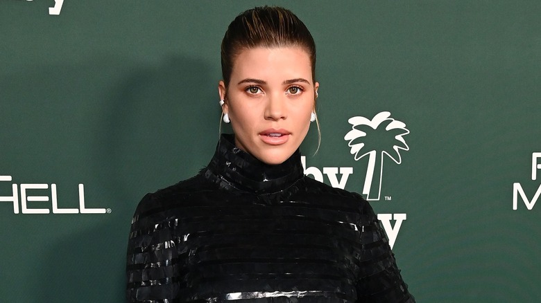 Sofia Richie en robe à col roulé noire brillante