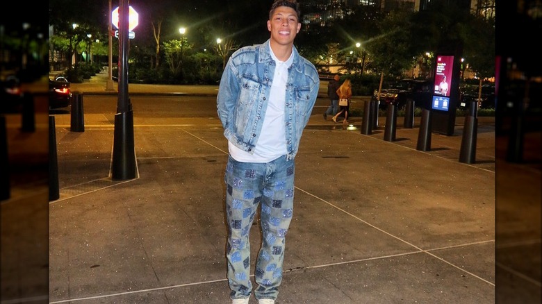 Jackson Mahomes se tient sur le trottoir avec une veste en jean bleue