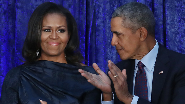 Michelle sourit pendant que Barack applaudit