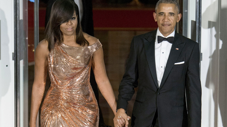 Barack et Michelle Obama se tiennent la main lors d'un événement à la Maison Blanche