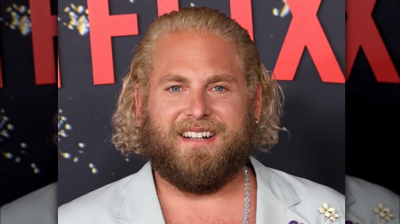 Jonah Hil souriant sur le tapis rouge