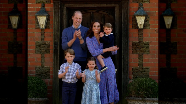 Le prince William, Kate Middleton et leurs enfants se tiennent devant la porte du chalet