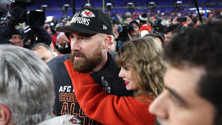 Taylor Swift avec ses bras enroulés autour de Travis Kelce