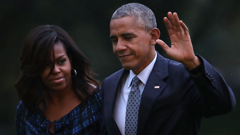 Barack Obama salue en marchant avec Michelle