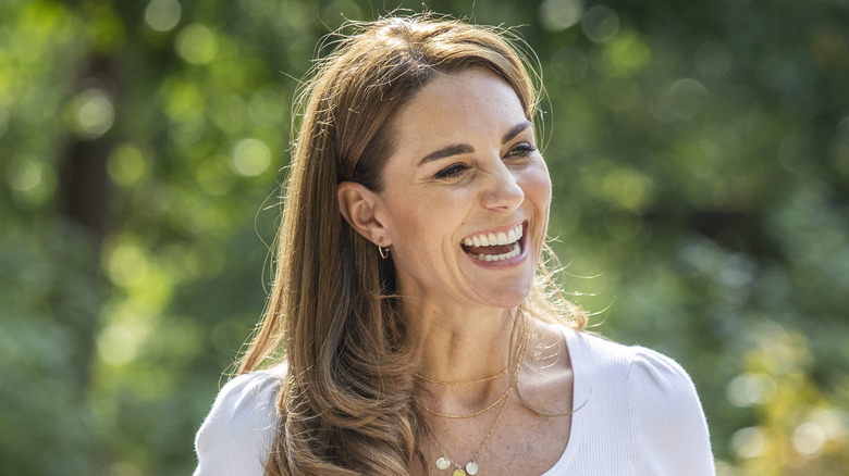 Kate Middleton en haut blanc en train de rire