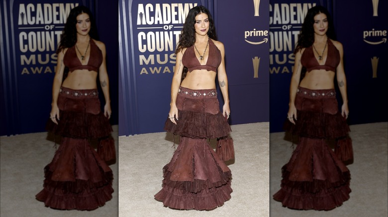 Kassie Ashton portant un crop top et une jupe marron