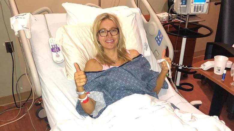 Kayleigh McEnany sourit en levant le pouce sur son lit d'hôpital.