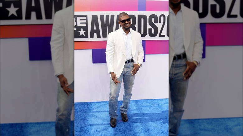 Usher pose en chemise blanche et jean