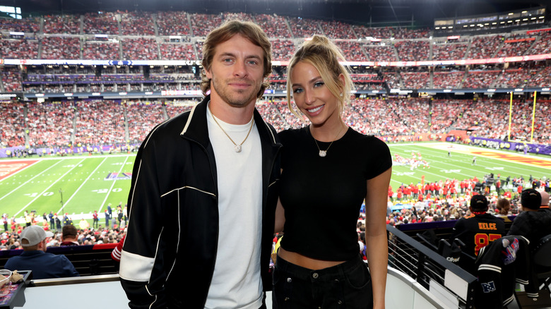 Braxton Berrios et Alix Earle souriant lors d'un match