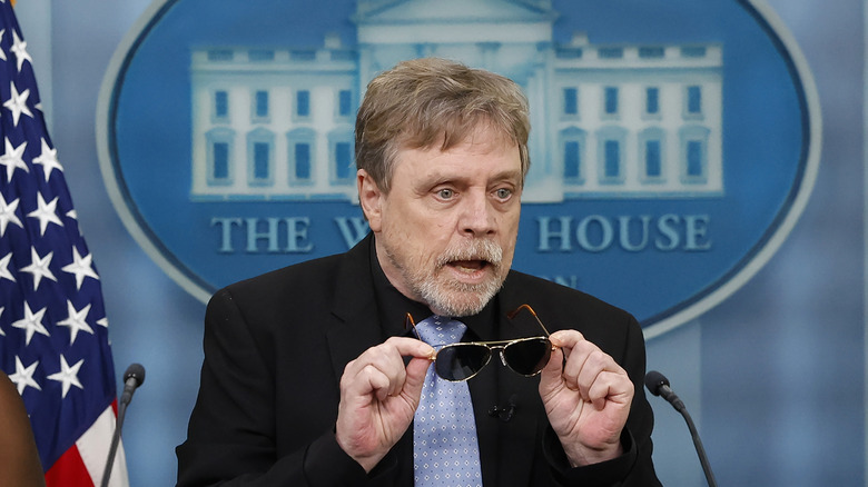 Mark Hamill tenant des lunettes de soleil