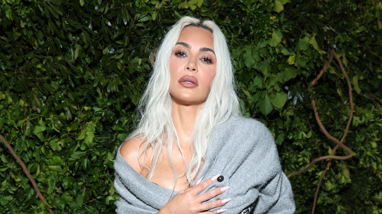 Kim Kardashian debout devant le feuillage