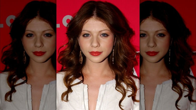 Michelle Trachtenberg posant devant un fond rouge