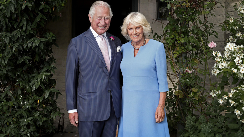 Le roi Charles et la reine Camilla posant en extérieur