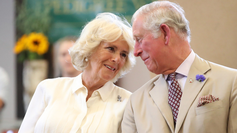 La reine Camilla et le roi Charles, tous deux souriants l'un à l'autre