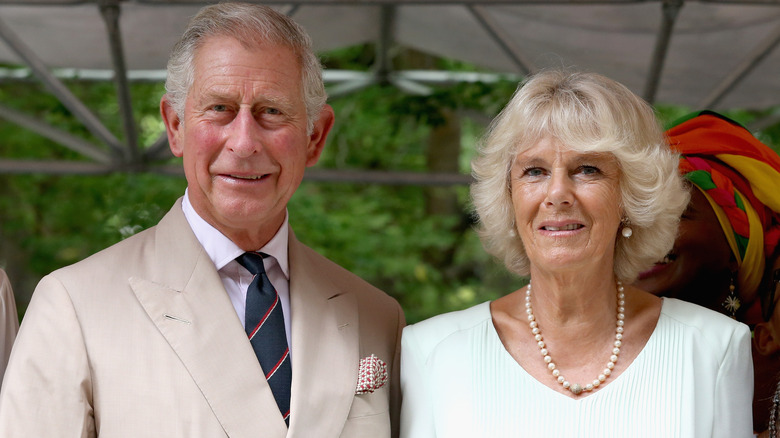 Le roi Charles et la reine Camilla, souriant ensemble à l'ombre