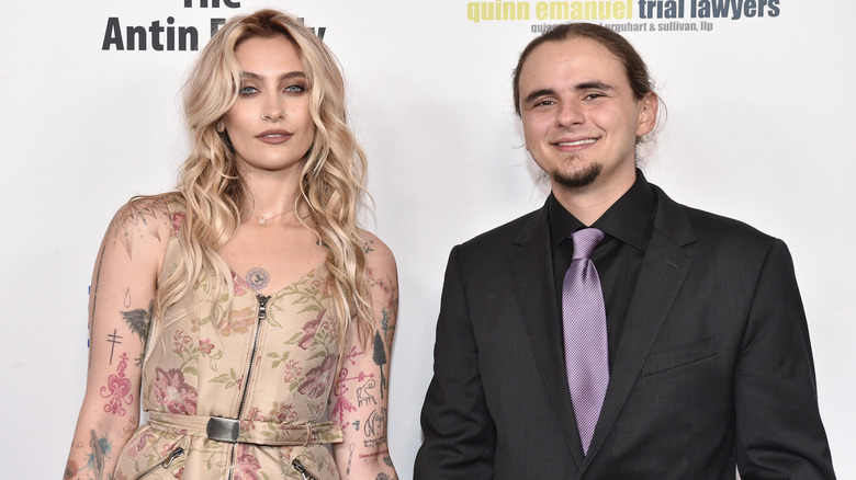 Paris Jackson porte une robe fleurie beige avec Prince Jackson portant une veste noire, une chemise noire et une cravate violette