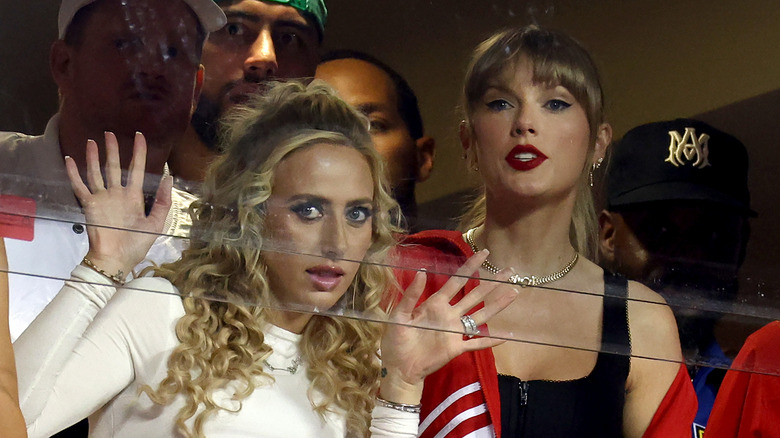 Brittany Mahomes avec les mains sur la vitre à côté de Taylor Swift